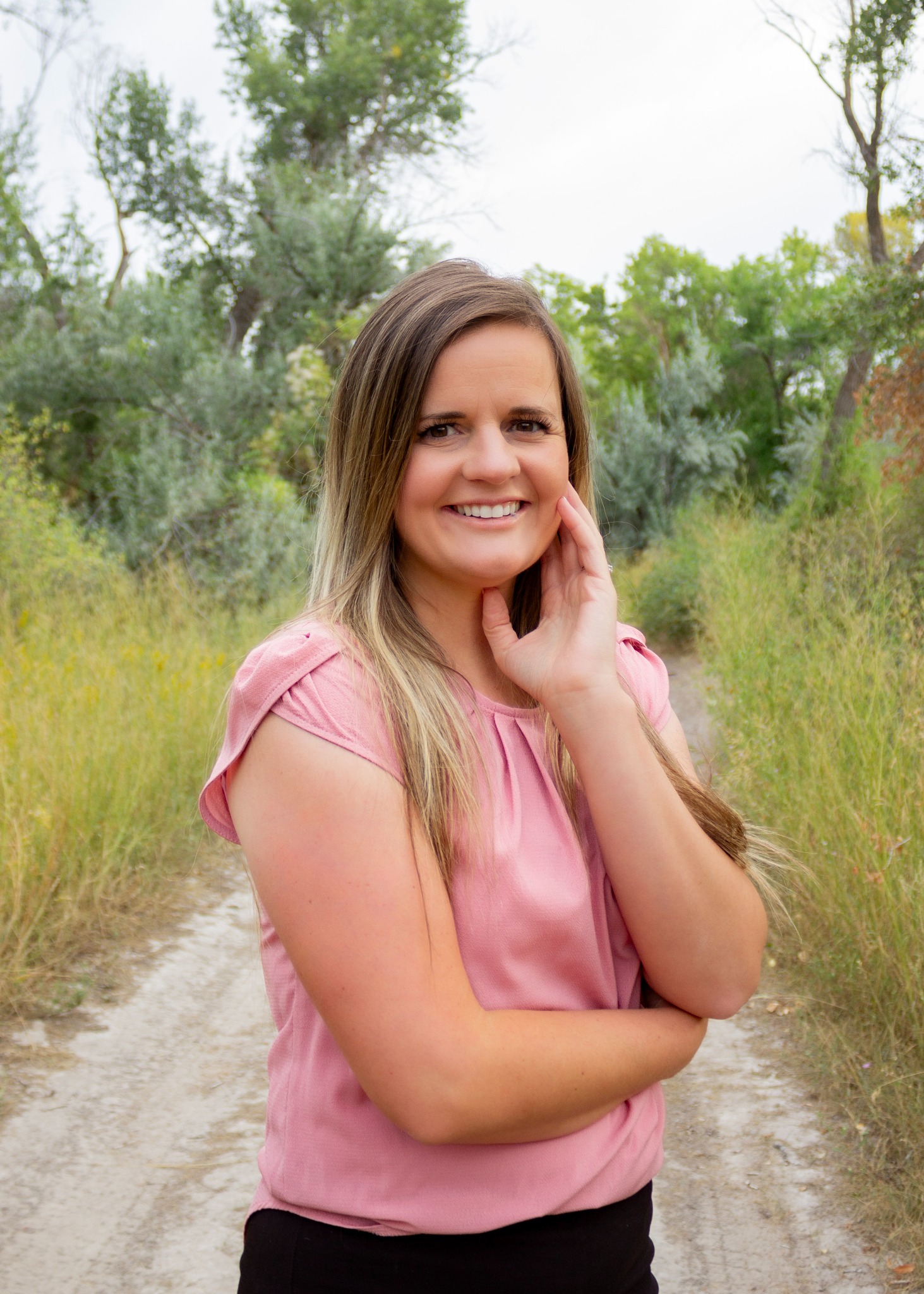 Shalese Bruce smiling outdoors on a wooded path